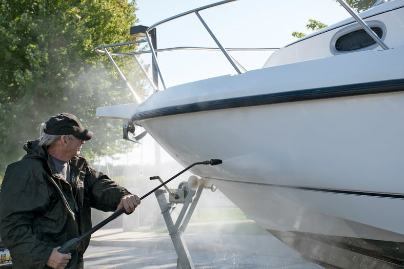 Caucasian man power washing boat